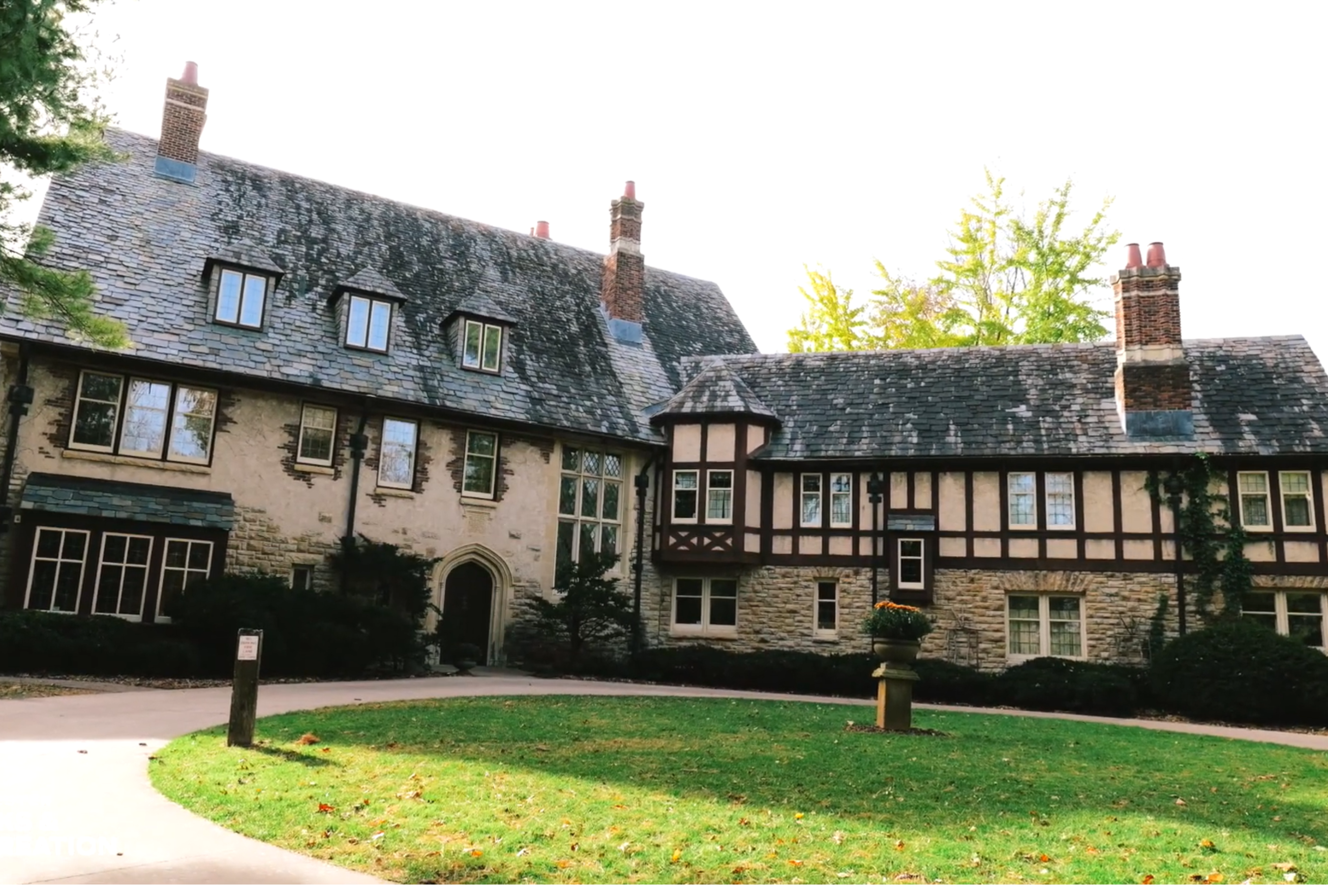 Exterior view of a historic brick building with a circular walkway approaching it's front