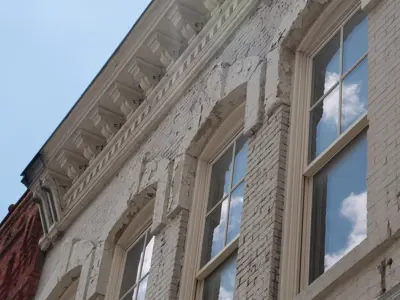 a view up at windows set in a historic white brick building