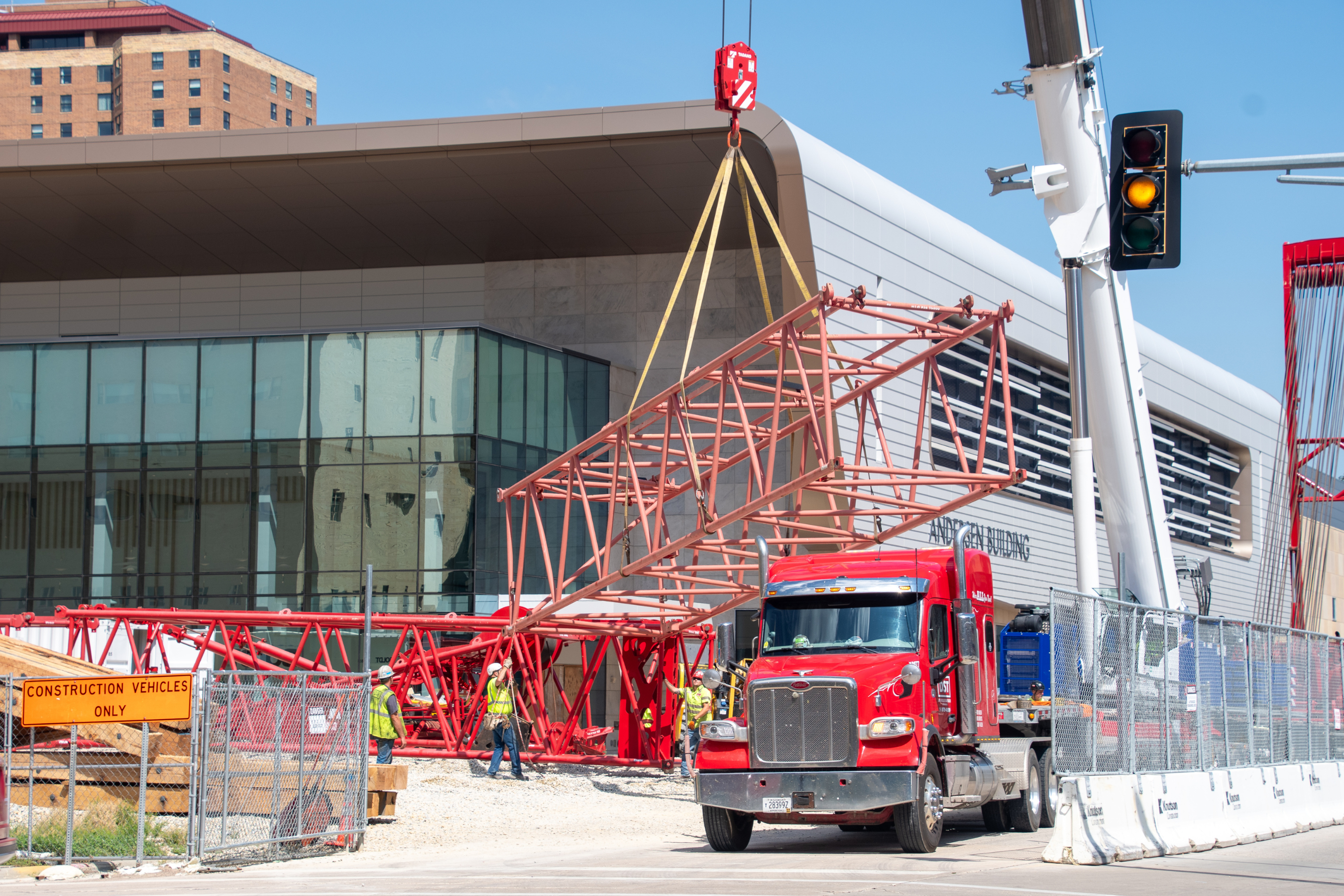 a crane transporting a large metal structure on a construction site
