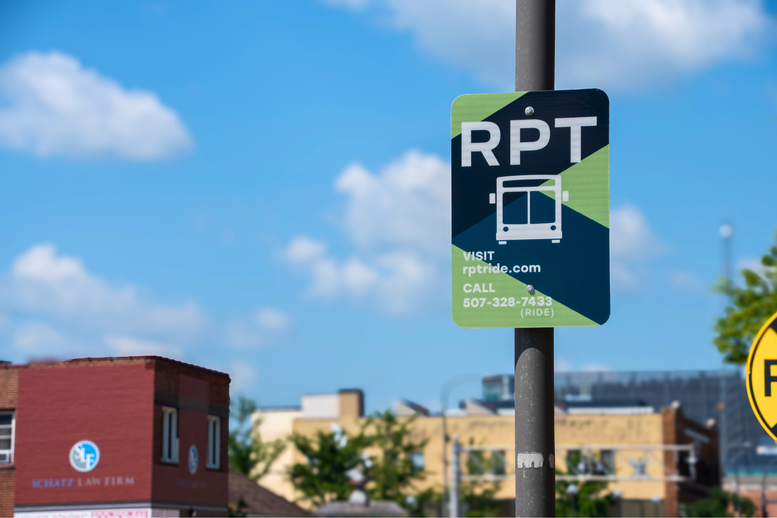 a street signing designating a rochester public transit bus stop, reading 'RPT visit rptride.com call 507-328-7433'